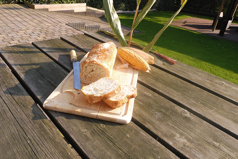 Maisbrood op snijplank met mes